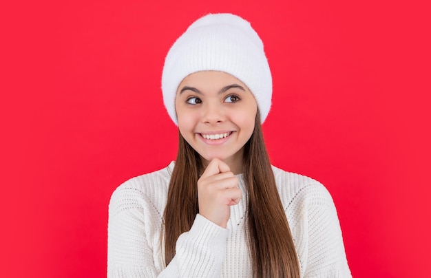 Teen girl u?miech w sweter z dzianiny zimowej w studio Teen winter girl wyizolowanych na czerwonym tle