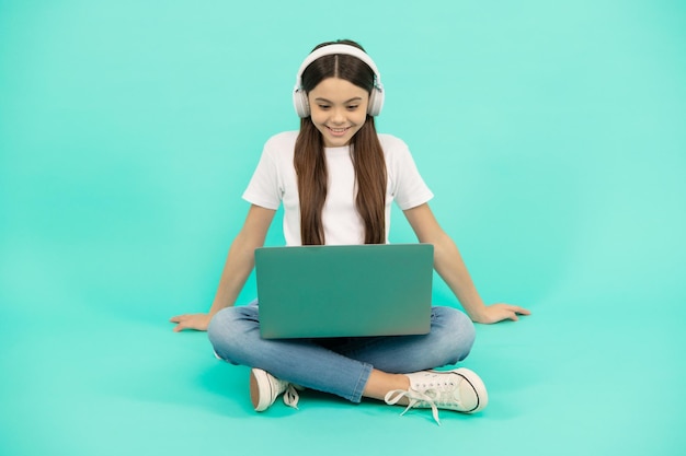 Teen influencer blogowanie szczęśliwa dziewczyna w słuchawkach webinar w bezprzewodowym zestawie słuchawkowym nowoczesna edukacja technologia komunikacji rozwój dzieciństwo dziecko czat na laptopie kup online powrót do szkoły