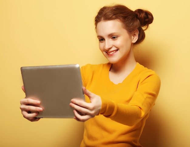 Tehnologia Stylu życia I Koncepcja Ludzi Szczęśliwa Rudowłosa Dziewczyna Biorąca Selfie Z Cyfrowym Tabletem Na żółtym Tle
