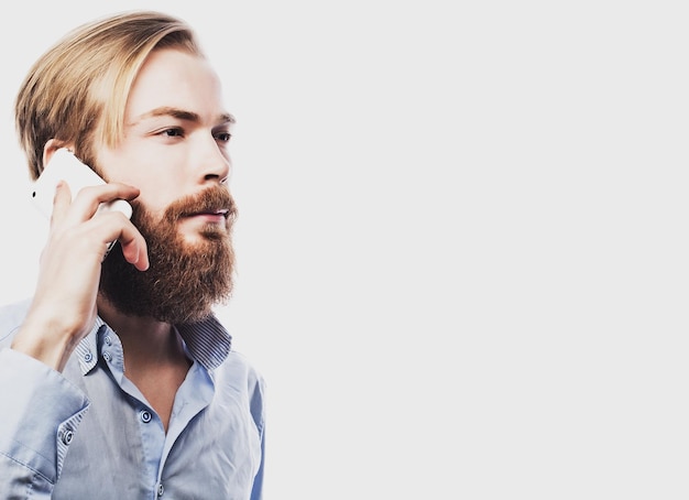 Tehnology internet koncepcja emocjonalna i ludzie młody brodaty mężczyzna rozmawia na telefonie komórkowym na białym tleSpecjalne modne tonowanie
