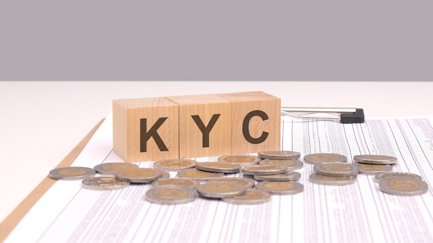 Tekst kyc na drewnianych kostkach na drewnianym stole z monetami ta koncepcja podkreśla znaczenie wiedzy