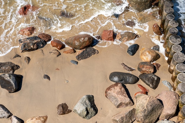 Tekstura kamiennego piasku i fal na wybrzeżu morskim