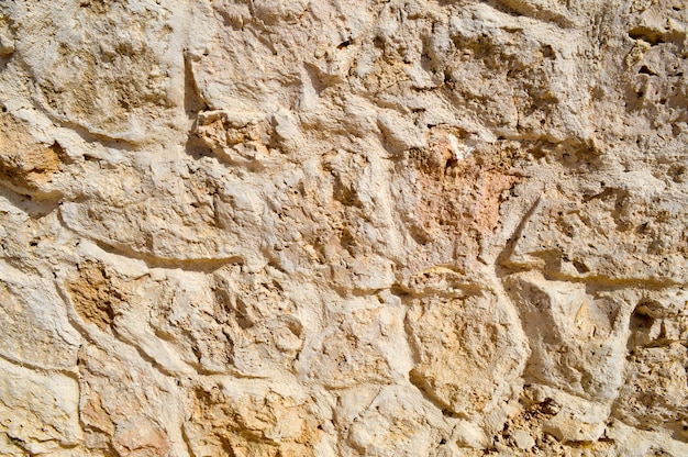 Tekstura kamiennej ściany dróg z kamieni cegieł bruku płytki z piaszczystymi szwami szarej starożytności