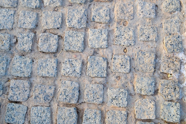 Tekstura kamiennej ściany dróg z kamieni cegieł bruku płytki z piaszczystymi szwami szarości