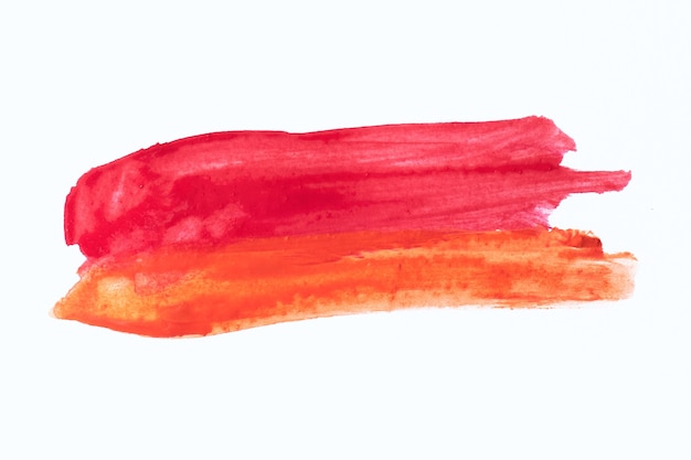 Zdjęcie tekstura o wysokiej rozdzielczości z pociągnięciami pędzla w kolorze czerwonym i pomarańczowym na białym tle.