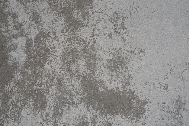 Tekstura otynkowanej ściany Wybielona powierzchnia Abstrakcyjne tło Tekstura struktury zbudowanej w stylu retro Pęknięcia i nierówności na betonowej ścianie Nierówne zabarwienie farbą na bazie wody Stary postrzępiony tynk