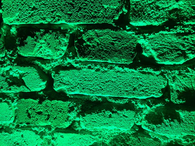 Zdjęcie tekstura ściany z cegły z zielonym podświetleniem tło dla banerów dekoracyjnych