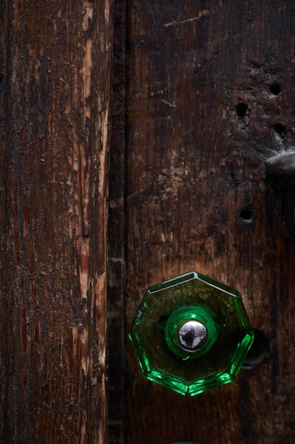 Tekstura starych drewnianych drzwi z zieloną rękojeścią