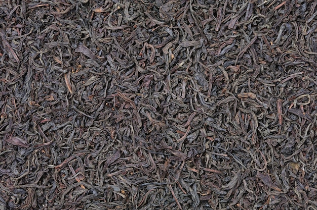 Tekstura suchej czarnej herbaty o dużych liściach