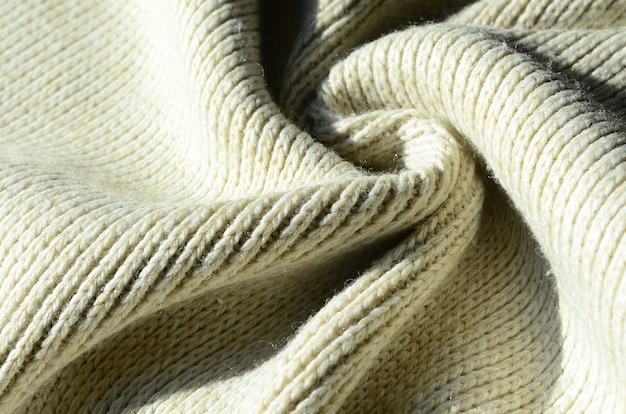 Tekstura tkaniny miękkiego żółtego swetra z dzianiny. Makro obraz struktury wiązań w przędzach