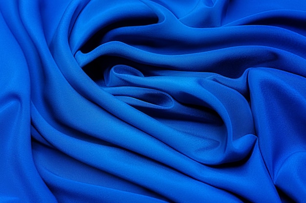 Tekstura, tło, wzór. Tekstura niebieskiej tkaniny jedwabnej lub bawełnianej lub wełnianej. Piękny wzór tkaniny.