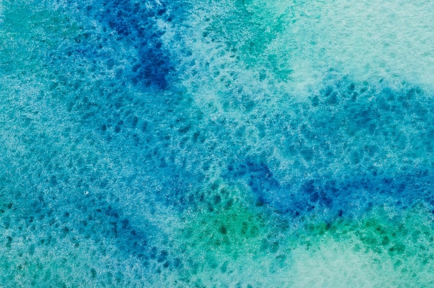 Tekstura z niebieskich i zielonych plam akwarelowych na białym papierze
