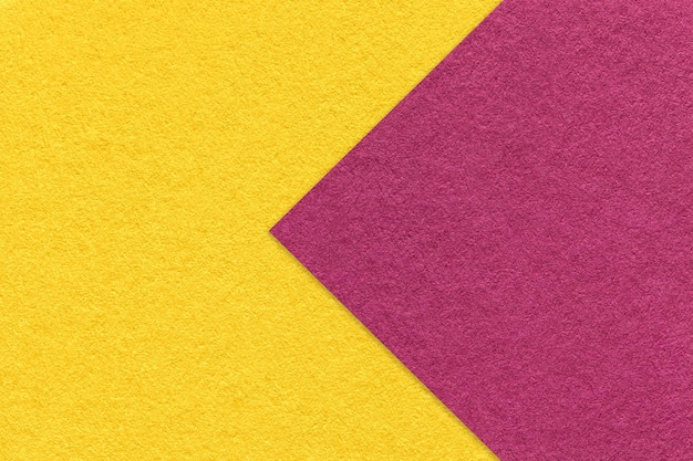 Tekstura żółtego papierowego tła pół dwa kolory z purpurową strzałkowatą makro- Rzemiosło złoty karton