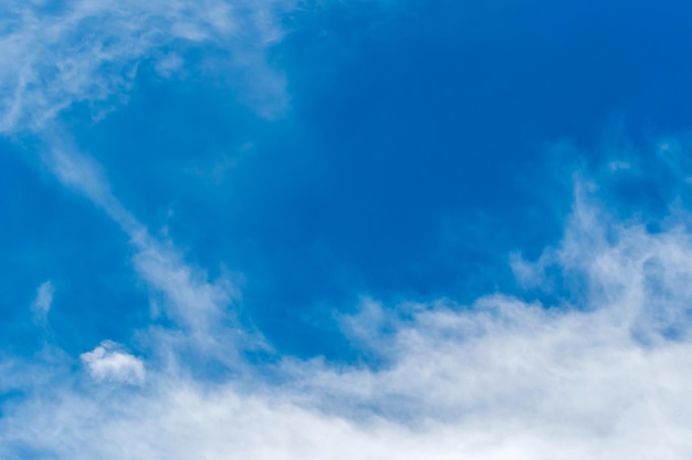 Teksturowane tło pięknego błękitnego nieba z kilkoma chmurami