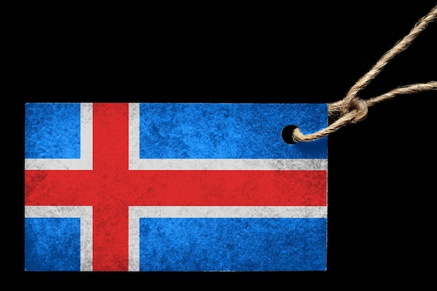 Tekturowa metka w kolorze flagi Islandii z nitką na czarnym tle