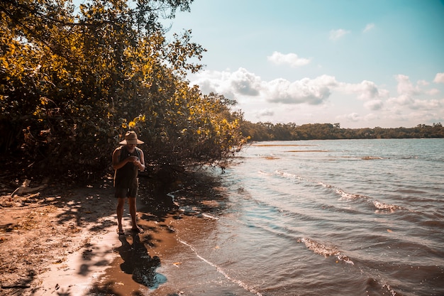 Tela, Honduras: młody miejscowy w kapeluszu na plaży Punta de Sal na Morzu Karaibskim z kamerą akcji na plaży