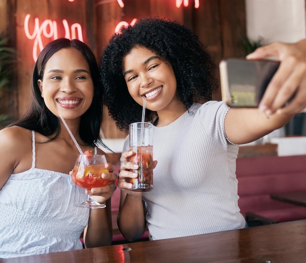 Telefon koktajlowy lub przyjaciele robiący selfie do tworzenia treści w mediach społecznościowych podczas wakacji w restauracji Uśmiechnięte dziewczyny lub szczęśliwe kobiety robiące zdjęcia z napojami jako fajne lub zabawne wpływowe osoby