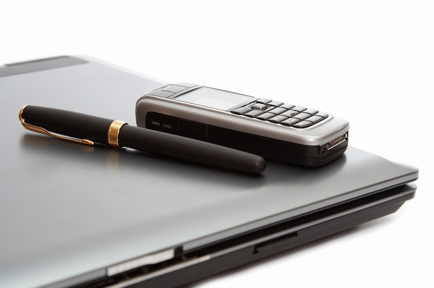Telefon komórkowy i wieczne pióro na laptopie
