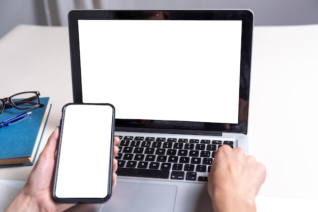 Zdjęcie telefon komórkowy na pierwszym planie białym tle i laptop zakupy koncepcja komunikacji online