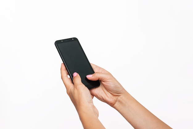 Telefon komórkowy z czarnym ekranem w kobiecych rękach na białym tle Kobieta używająca telefonu