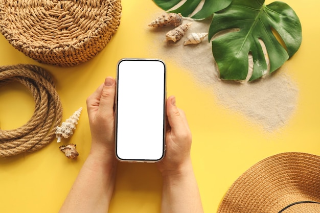 Telefon w rękach z izolowanym ekranem na tle letnich akcesoriów miejsce na Twoją reklamę
