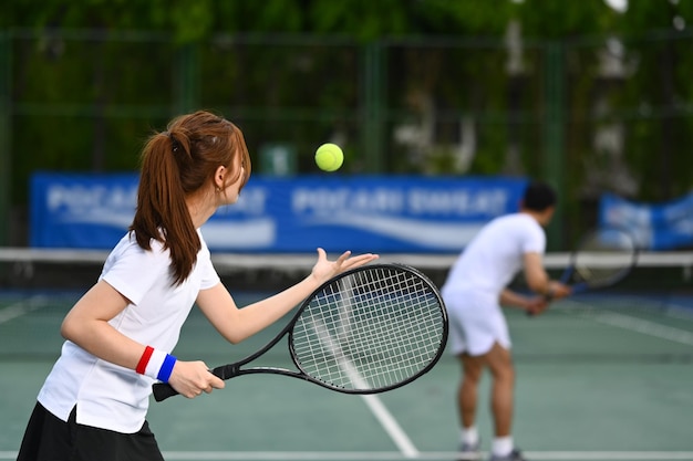Tenisista serwujący piłkę tenisową podczas meczu na otwartym korcie Sportowy trening fitness i koncepcja aktywnego życia