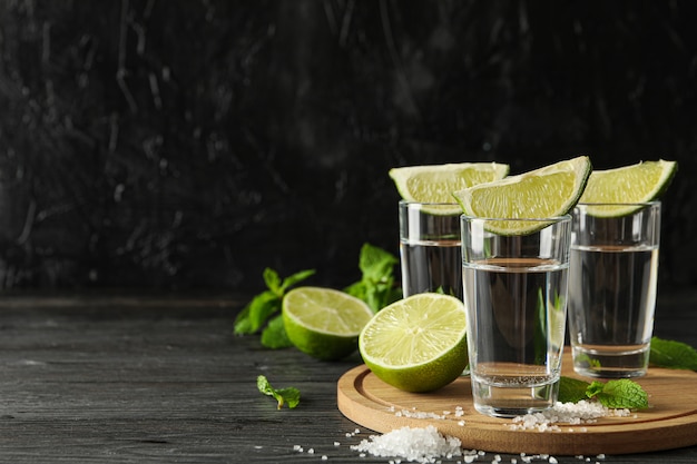 Tequili strzały z plasterkami limonki, solą i miętą na drewnianym