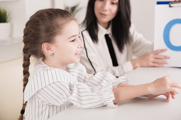 Terapeuta Pracująca Z Dzieckiem Z Problemem Wymowy W Białej Szafce.