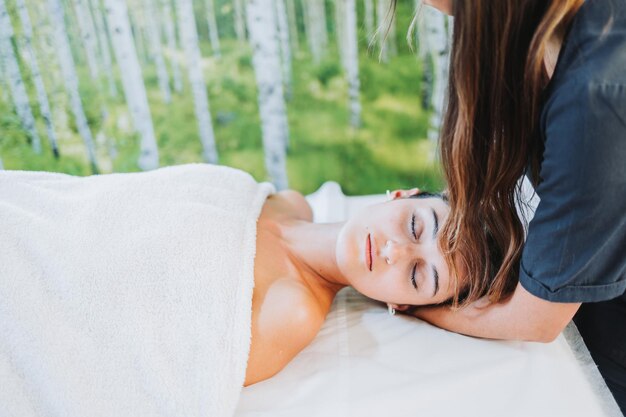 Terapeuta wykonująca masaż karku z pochyloną głową pacjentka Centrum odnowy biologicznej spa