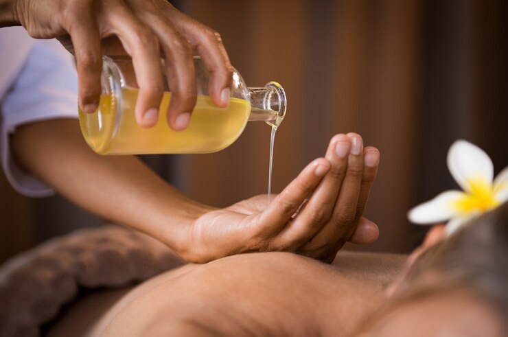 Terapeuta wylewający olej masażowy w spa