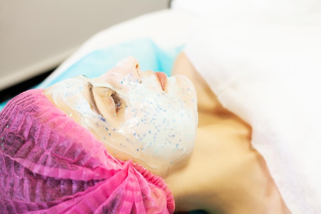 Terapia Spa dla młodej kobiety o maskę na twarz w salonie piękności.