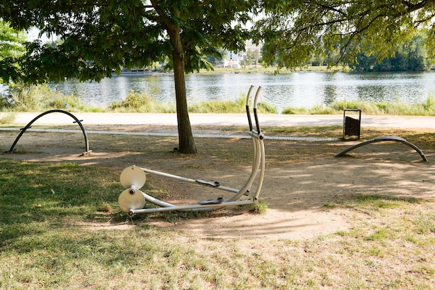 Teren zewnętrzny ze sportowym sprzętem do ćwiczeń w parku miejskim pustym na brzegu rzeki do ćwiczeń sportowych