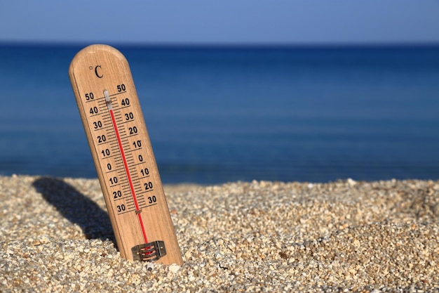 Zdjęcie termometr na plaży pokazuje wysokie temperatury