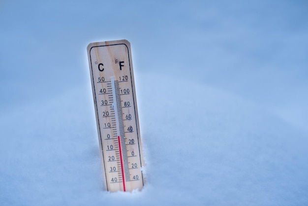 Termometr na śnieg z niską temperaturą w stopniach Celsjusza lub Fahrenheita zimą.