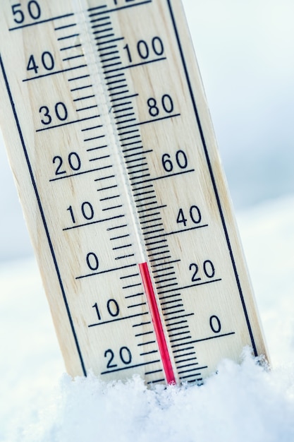 Termometr na śniegu pokazuje niskie temperatury zero. Niskie temperatury w stopniach Celsjusza i Fahrenheita. Zimna pogoda dwadzieścia zero.