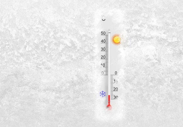 Termometr zewnętrzny na zamarzniętym oknie pokazuje temperaturę minus 25 stopni Celsjusza w mroźny zimowy dzień