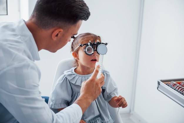 Testowanie wizji. Młody okulista przebywa w klinice z małą kobietą.