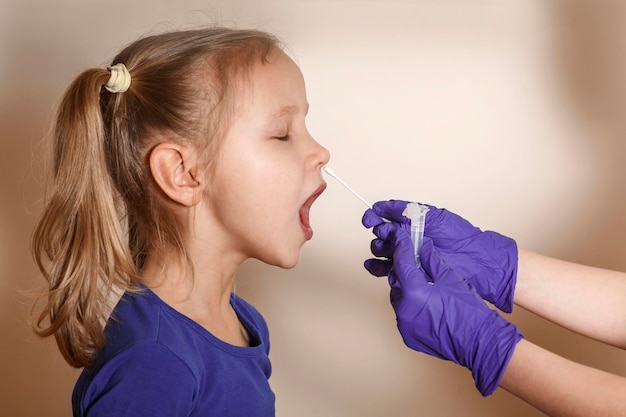 Zdjęcie testy na covid u dzieci. pobieranie wymazu z nosa u dziecka na jasnym tle