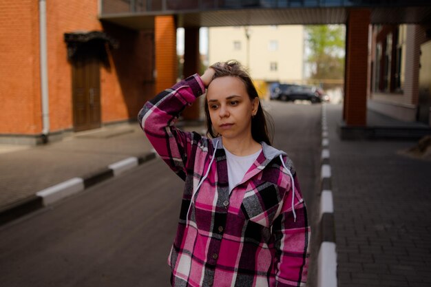 Zdjęcie thoughtful woman scratches head standing on street