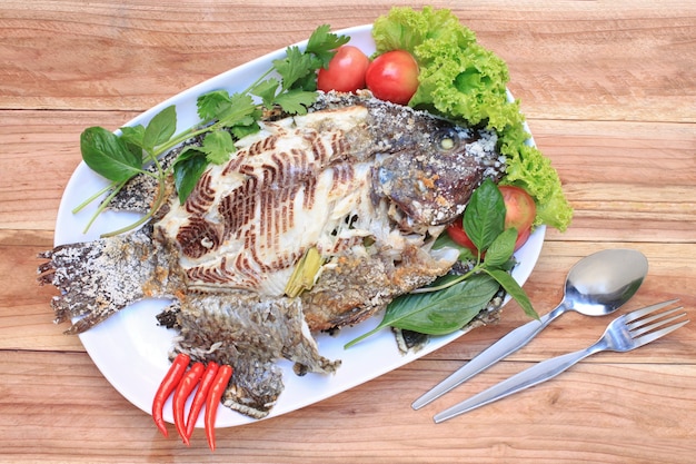 Tilapia ryba piec na grillu z solą w białym naczyniu.