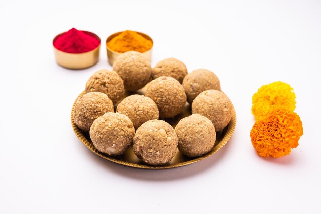 Zdjęcie tilgul lub til gul laddu lub sesame seed jaggery ball lub til ke laddo z kwiatem i haldu kumkum