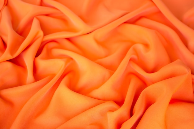 Tkanina pomarańczowa tło. tekstura tkanina miękka fala luksusowa tapeta wyświetlacz płaski leżał. dla koncepcji tło wakacje letnie wakacje tropikalne podróży.