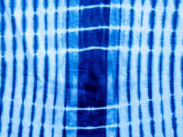 Tkanina w kolorze indygo w kolorze niebieskim. Tekstura tkaniny barwionej w kolorze indygo z abstrakcyjnym etnicznym motywem graficznym.