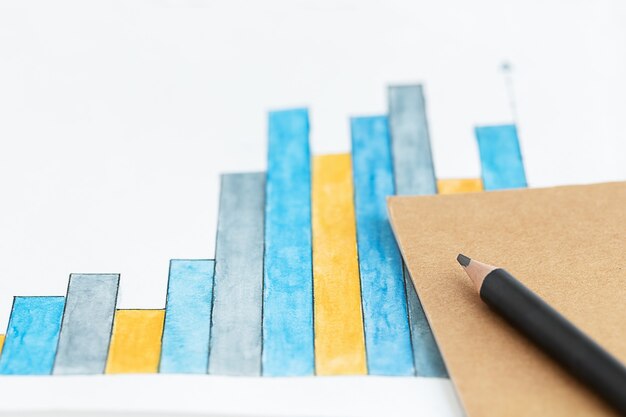 Zdjęcie tło biznesowe z ołówkowym notatnikiem i diagramem