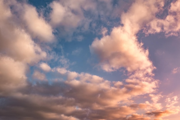 Tło błękitnego nieba z wieczorem puszyste kręcone toczenia chmury altocumulus altostratus z zachodzącym słońcem Dobra wietrzna pogoda