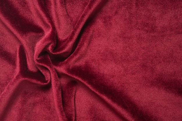 Tło czerwonego aksamitu. Abstrakcjonistyczna tekstylna tekstura z fala.