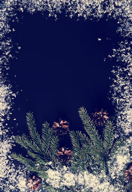 Tło dla nowego roku pozdrowienia z gałęzi drzew, szyszek i śniegu