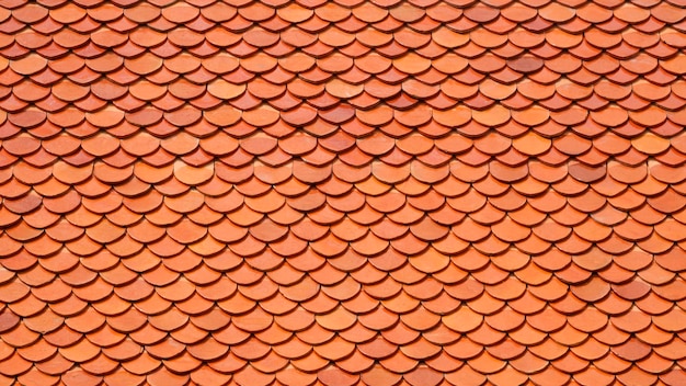 Tło i tekstura pomarańczowej dachówki z glinianej dachówki tajskiej świątyni