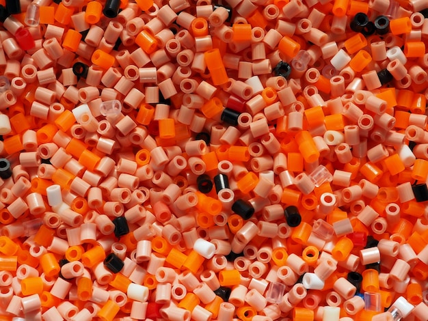 Tło kolorowych plastikowych koralików w pomarańczowych odcieniach