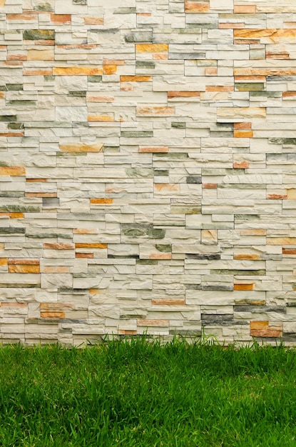 Tło ściany z kamieni i trawy Ściana wewnątrz ogrodu z teksturą kamieni